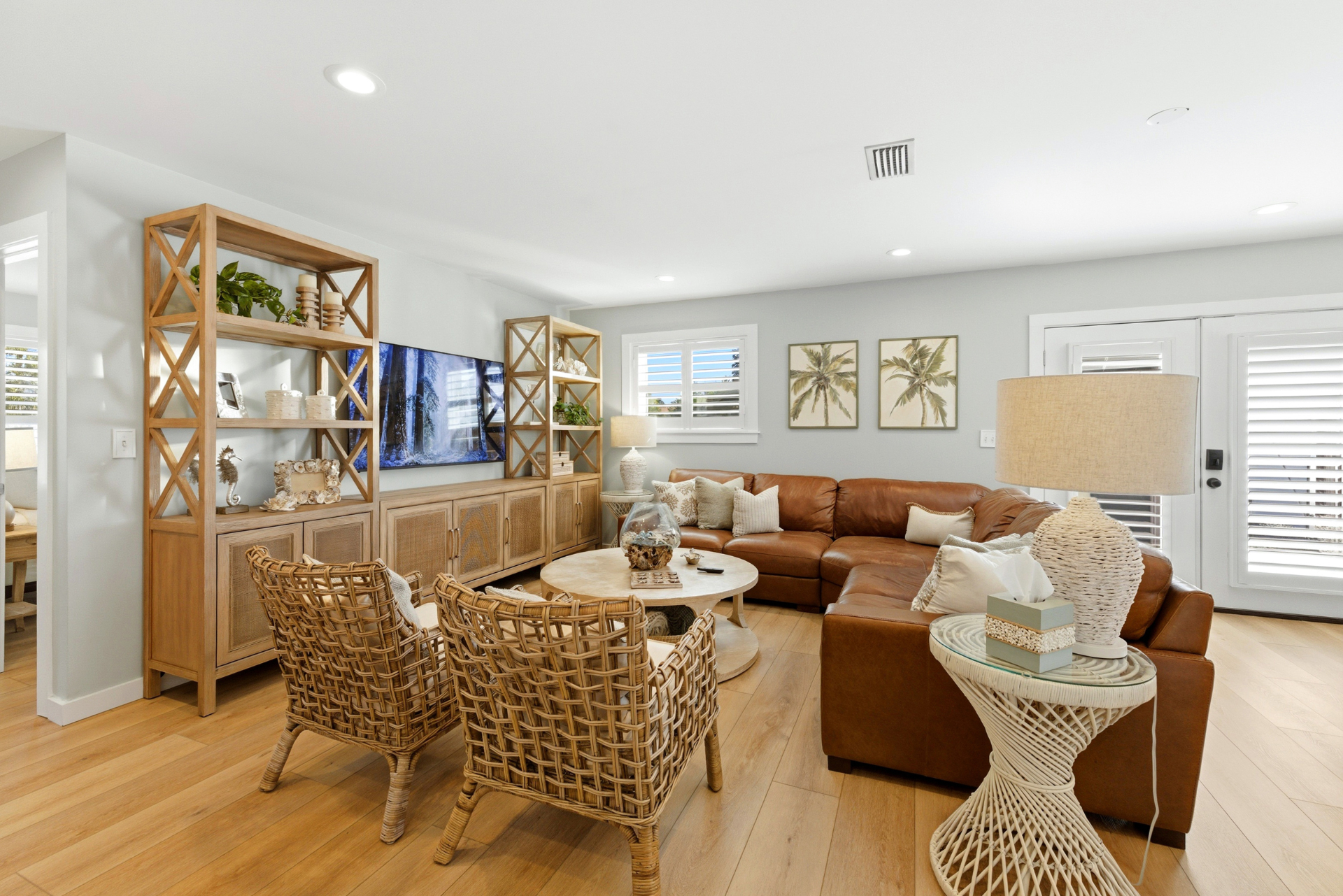 Beautifully designed coastal living room with rattan chairs and leather sofa